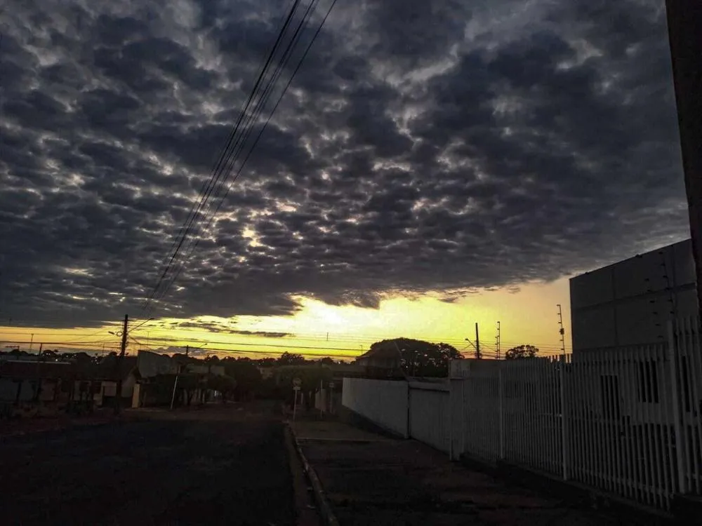 Céu encoberto por nuvens carregadas contrasta com a faixa de luz do amanhecer em Campo Grande nesta terça-feira (Foto: Simão Nogueira)